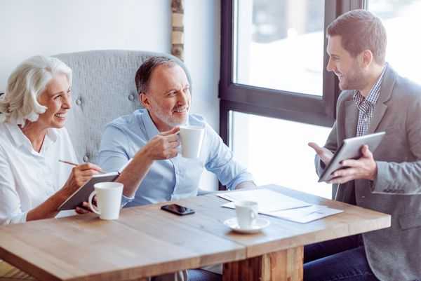 Older couple smiling having coffee with their divorce attorney