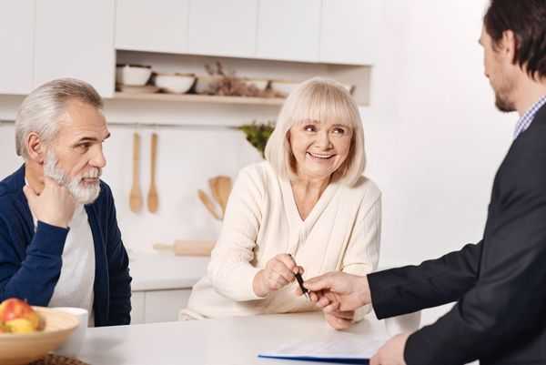 Older man and woman with their layer, signing a divorce agreement.